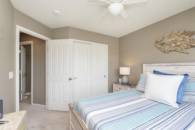 carpeted bedroom featuring ceiling fan and a closet