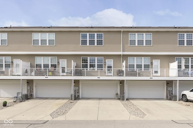 townhome / multi-family property featuring cooling unit and a garage