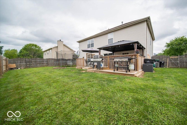 rear view of property featuring a yard, a gazebo, and a deck