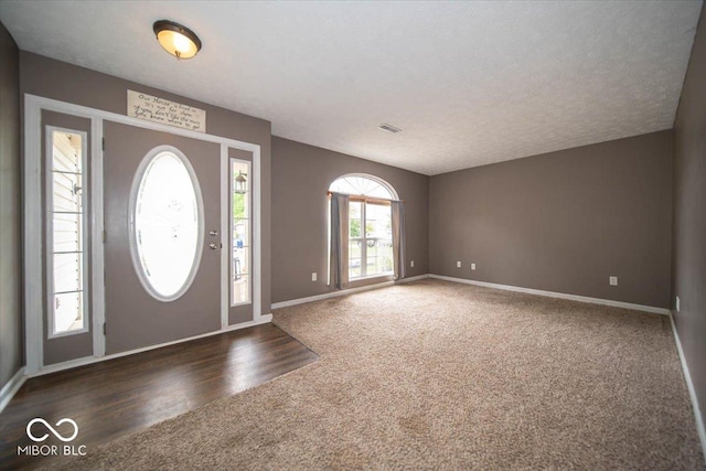 foyer with dark hardwood / wood-style floors and a textured ceiling