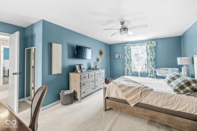 carpeted bedroom with a textured ceiling and ceiling fan