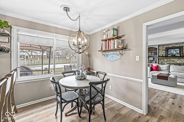 dining room featuring an inviting chandelier, hardwood / wood-style floors, and crown molding