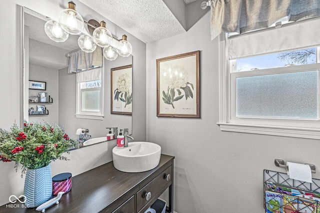 bathroom with a healthy amount of sunlight, vanity, and a textured ceiling