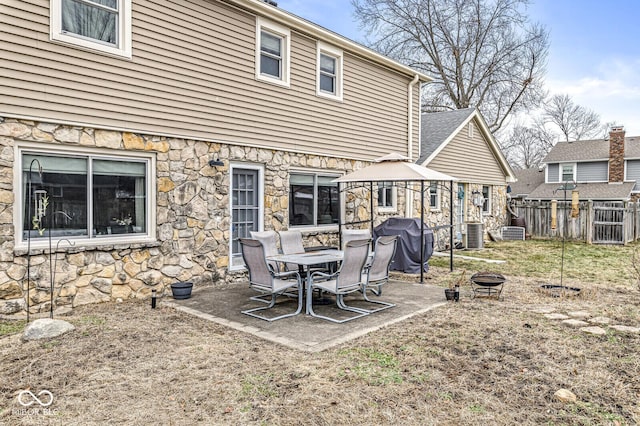 rear view of property with a gazebo, an outdoor fire pit, a patio, and central air condition unit