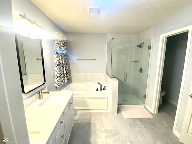 full bathroom featuring vanity, shower with separate bathtub, and toilet