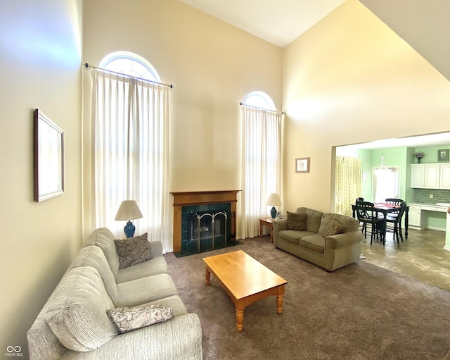 living room featuring a towering ceiling, a fireplace, and carpet