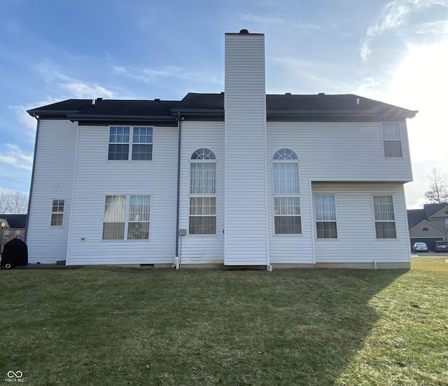 rear view of property featuring a yard