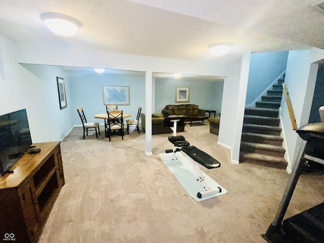 exercise area featuring a textured ceiling and carpet flooring