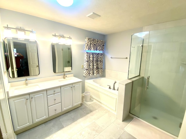 bathroom featuring vanity, plus walk in shower, and a textured ceiling