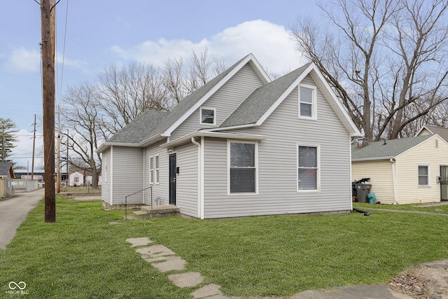 view of front of house featuring roof with shingles and a front yard