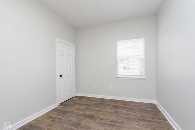 unfurnished room with baseboards and dark wood-style flooring