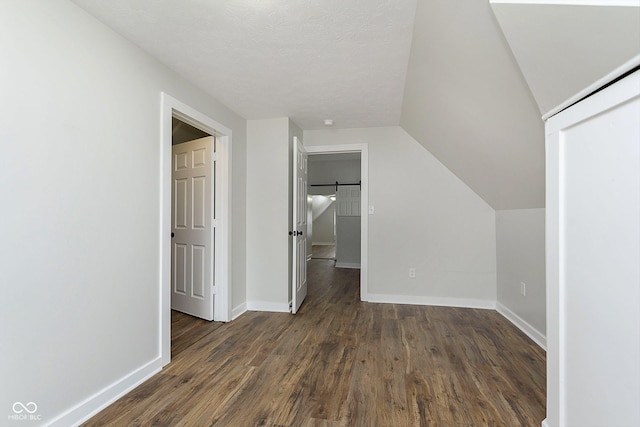 additional living space with dark wood-type flooring and vaulted ceiling