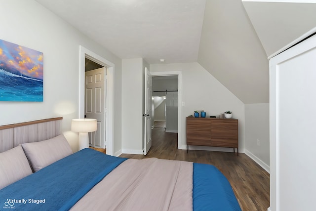 bedroom featuring lofted ceiling, dark wood-style flooring, and baseboards