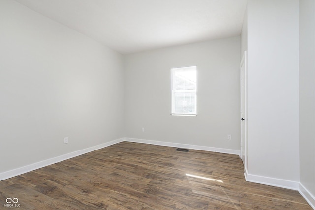 unfurnished room with dark wood-style flooring and baseboards