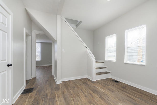 staircase with wood finished floors, visible vents, and baseboards