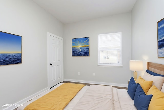 bedroom with baseboards and wood finished floors