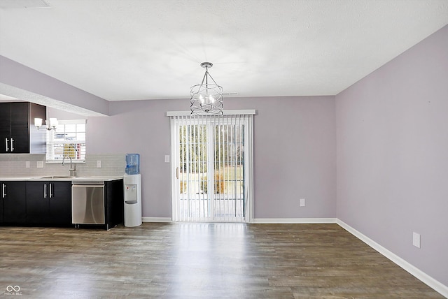 kitchen with pendant lighting, sink, dishwasher, tasteful backsplash, and a notable chandelier