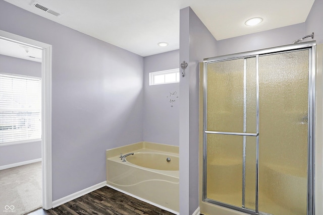 bathroom with hardwood / wood-style flooring and shower with separate bathtub