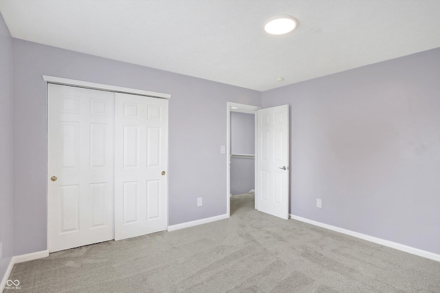 unfurnished bedroom with a closet and light carpet