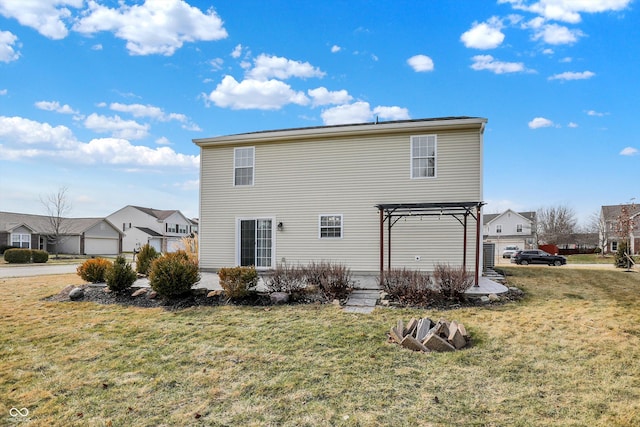 back of property featuring a garage, a pergola, and a lawn