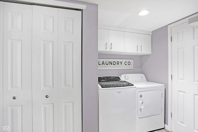 clothes washing area with cabinets and separate washer and dryer