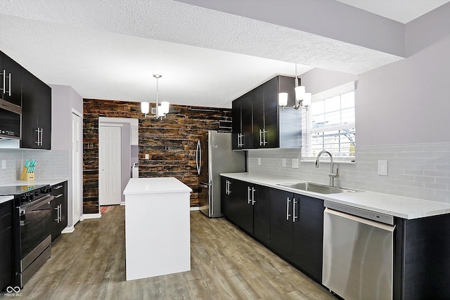 kitchen featuring decorative light fixtures, stainless steel appliances, a chandelier, and a kitchen island