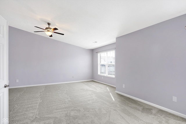 spare room featuring light carpet and ceiling fan