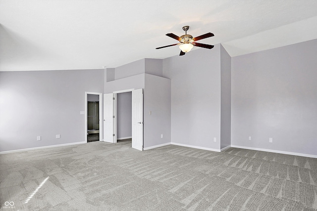 empty room featuring vaulted ceiling, light carpet, and ceiling fan