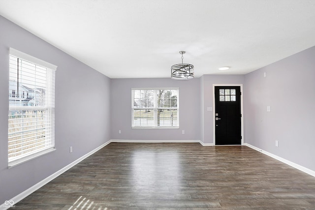 foyer entrance featuring an inviting chandelier and dark hardwood / wood-style flooring