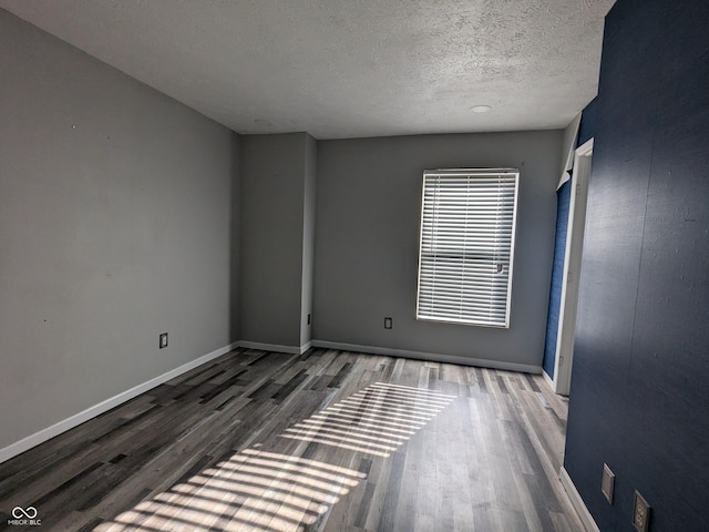 spare room with hardwood / wood-style floors and a textured ceiling