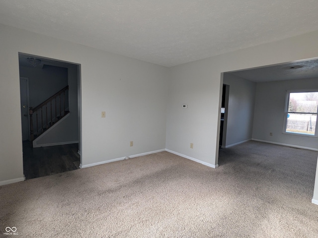 carpeted empty room with a textured ceiling