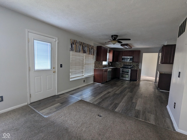 kitchen with sink, dark brown cabinets, dark hardwood / wood-style flooring, stainless steel appliances, and decorative backsplash