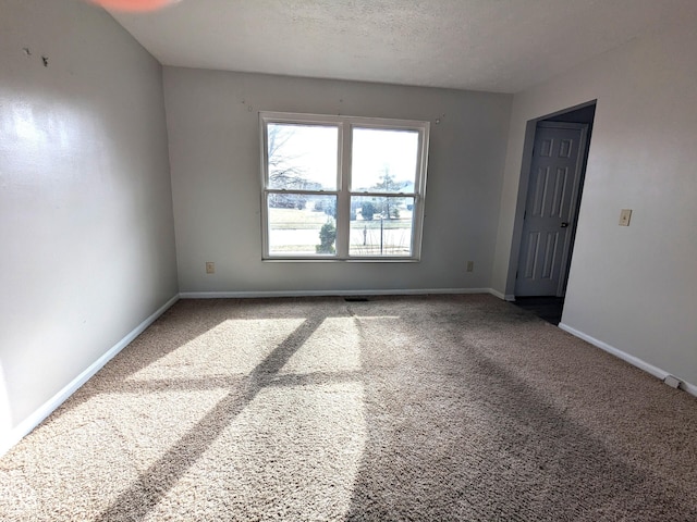 carpeted spare room featuring a textured ceiling