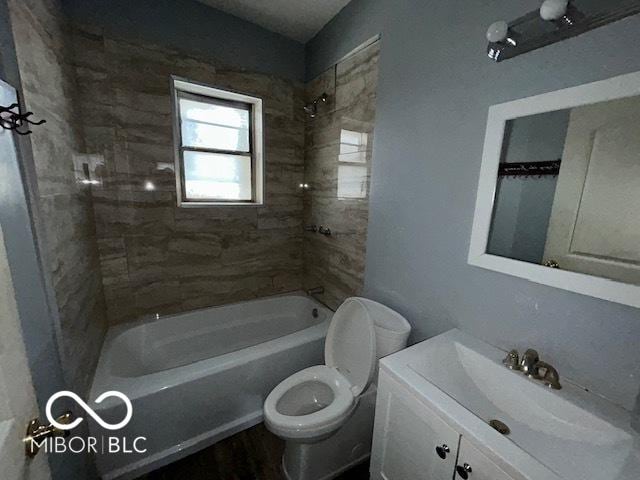 full bathroom with vanity, tiled shower / bath combo, and toilet