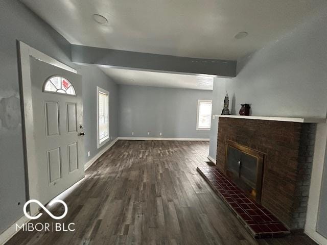 interior space with a fireplace, dark hardwood / wood-style flooring, and beam ceiling