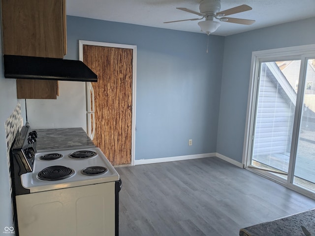 kitchen featuring ceiling fan, range with electric stovetop, light hardwood / wood-style floors, and wall chimney exhaust hood