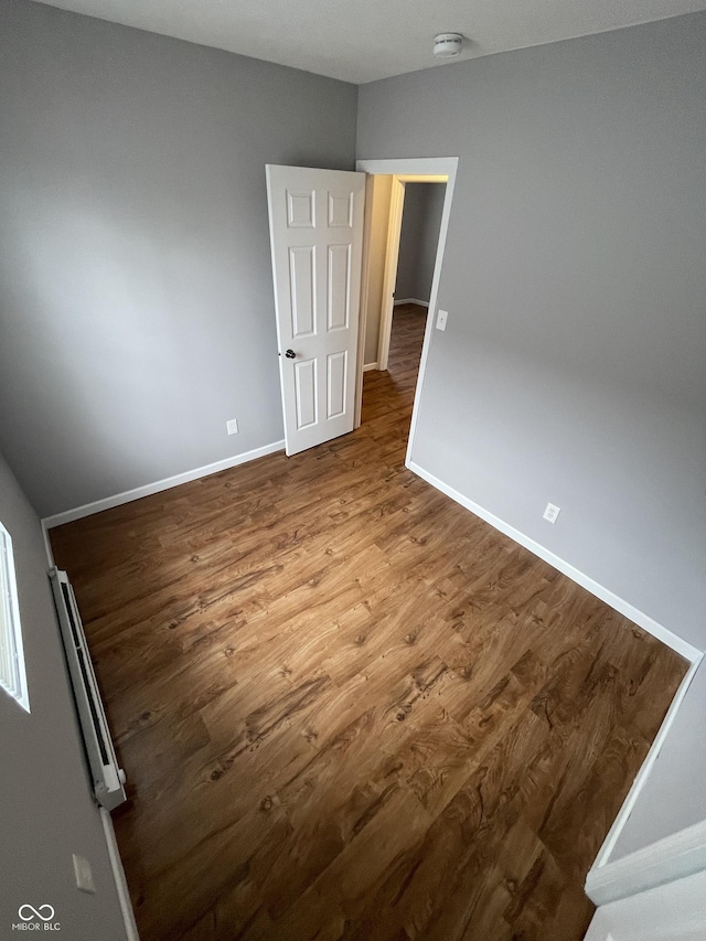 unfurnished room with baseboards and wood finished floors