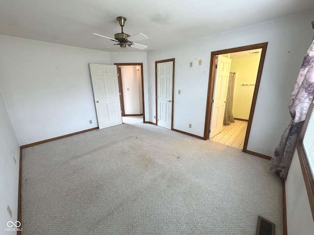 unfurnished bedroom featuring light carpet, ceiling fan, and ensuite bathroom