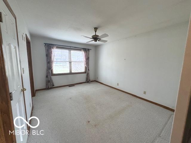 unfurnished room with light carpet and ceiling fan