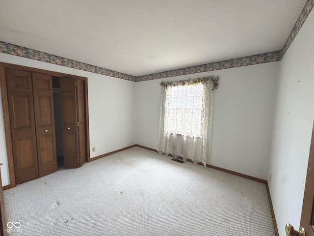 unfurnished bedroom featuring light carpet and a closet