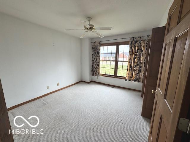 empty room with ceiling fan and light colored carpet