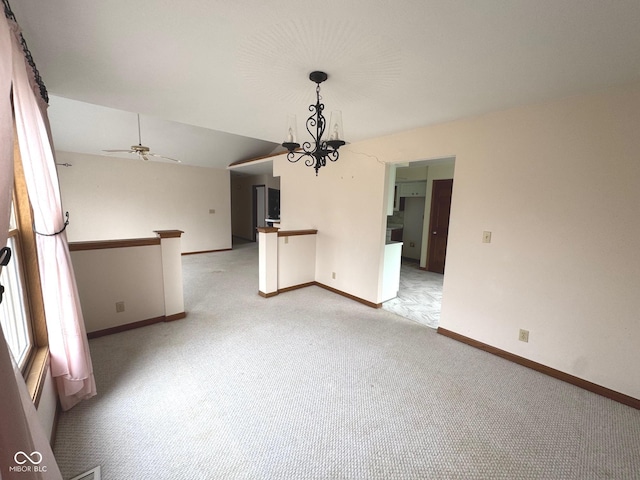 interior space with light carpet, ceiling fan with notable chandelier, and lofted ceiling