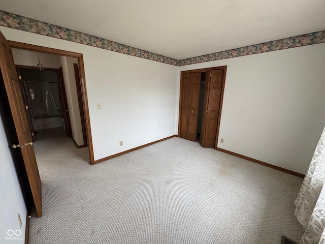 unfurnished bedroom with light colored carpet and a closet