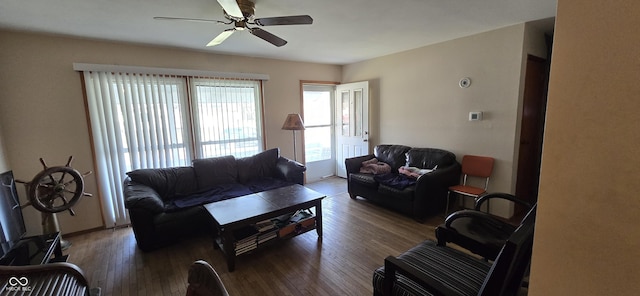 living room with dark wood-type flooring and ceiling fan