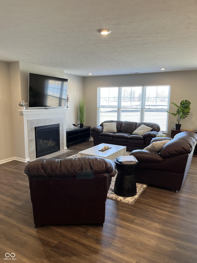 living room featuring dark hardwood / wood-style flooring, a fireplace, and a textured ceiling