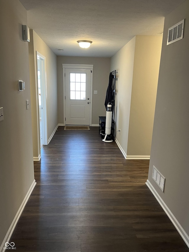 doorway to outside featuring dark hardwood / wood-style floors and a textured ceiling