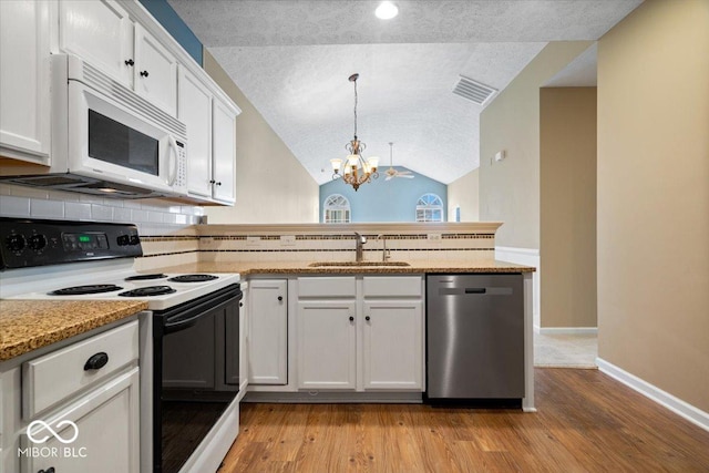 kitchen featuring range with electric cooktop, dishwasher, white cabinetry, sink, and hanging light fixtures