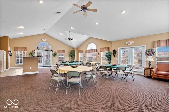 carpeted dining area featuring lofted ceiling, french doors, and a healthy amount of sunlight