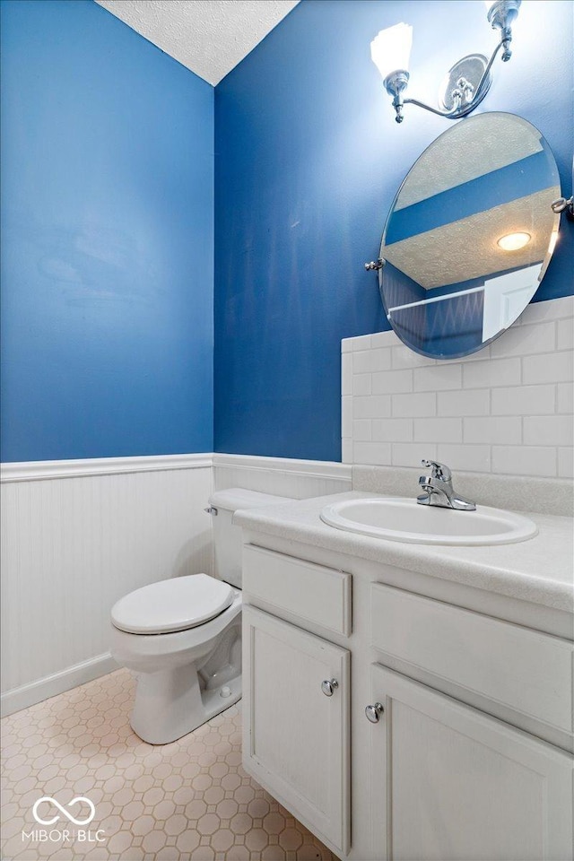 bathroom featuring vanity, toilet, and a textured ceiling