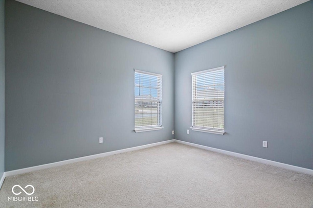 carpeted empty room with a textured ceiling